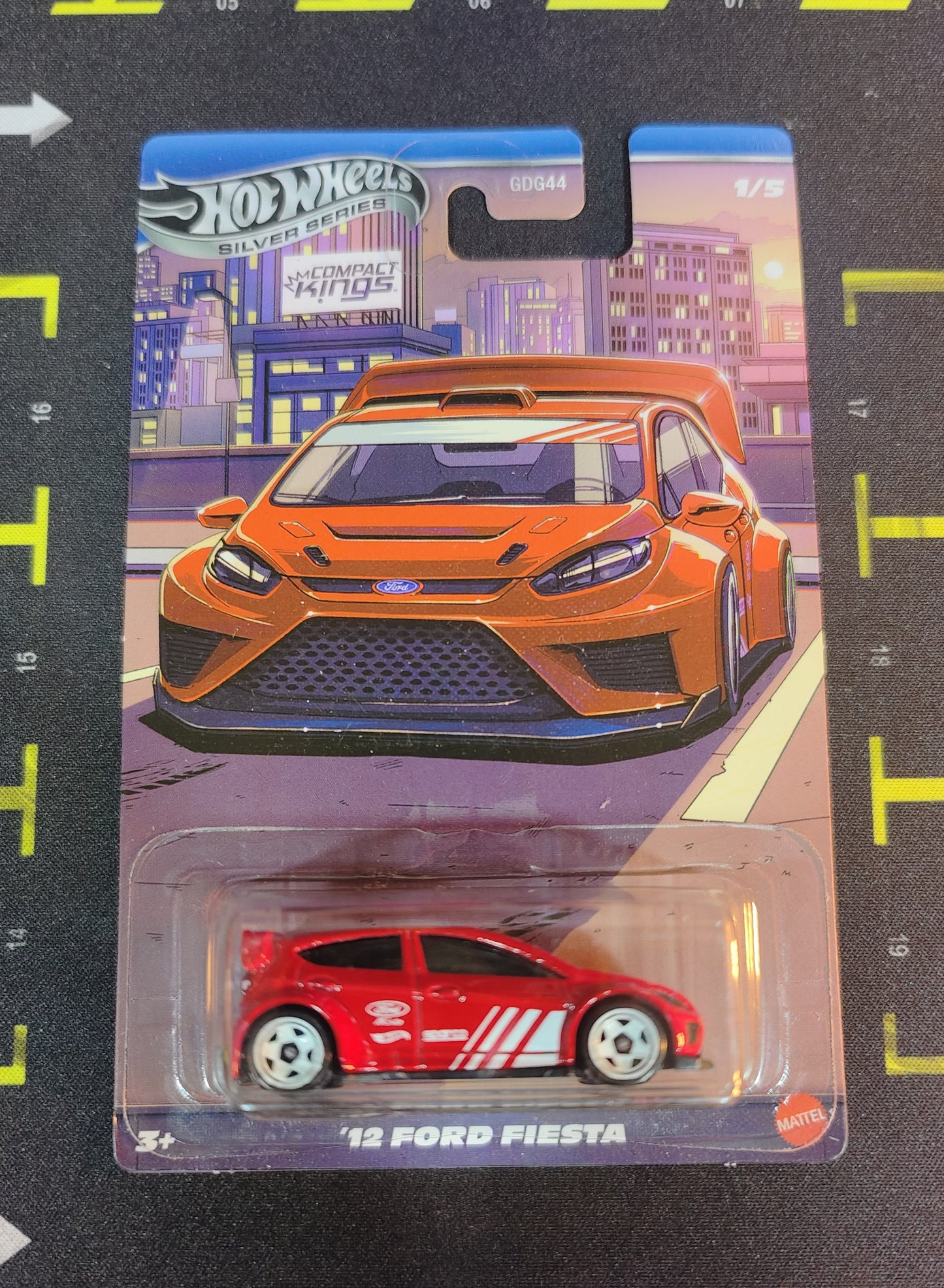 Hot Wheels '12 Ford Fiesta toy car in packaging with cityscape background