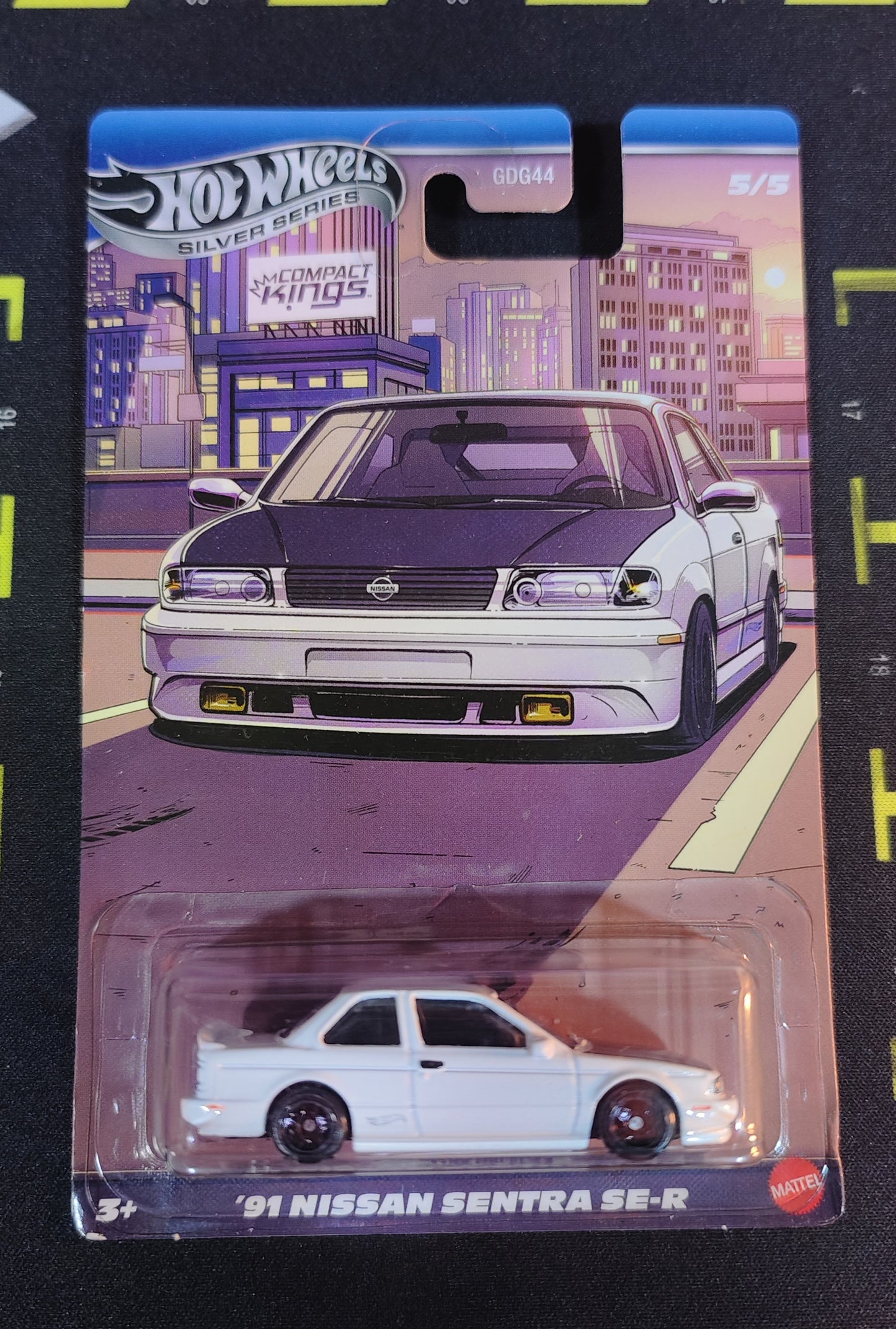 Hot Wheels '91 Nissan Sentra SE-R toy car in packaging with cityscape background