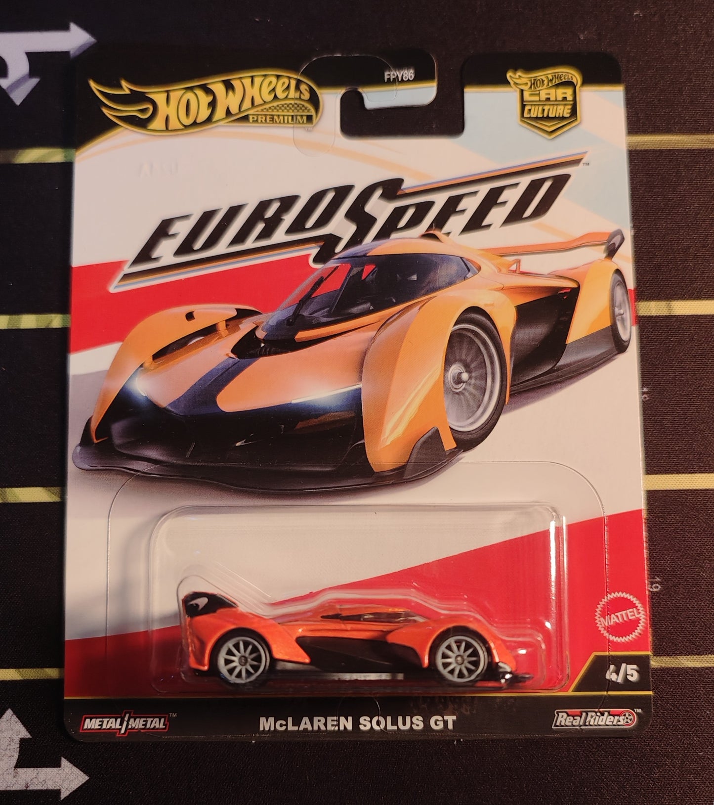 Hot Wheels McLaren Solus GT toy car in packaging on a striped background