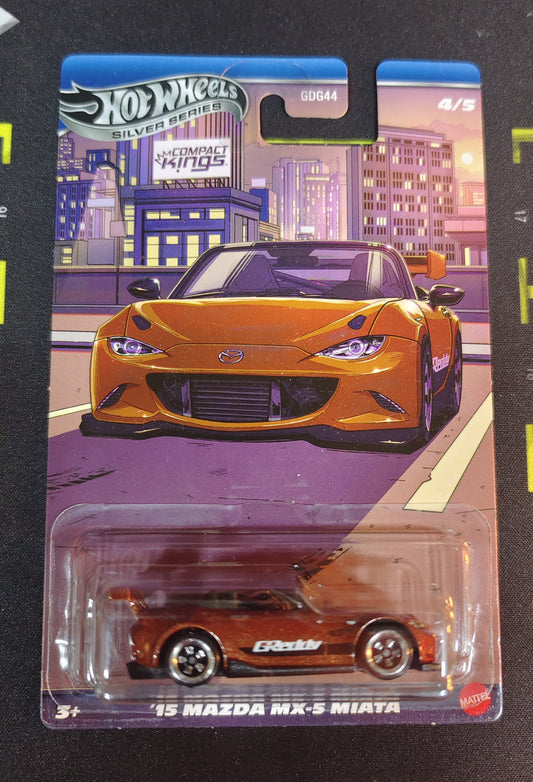 Hot Wheels '95 Mazda MX-5 Miata toy car in packaging with cityscape background