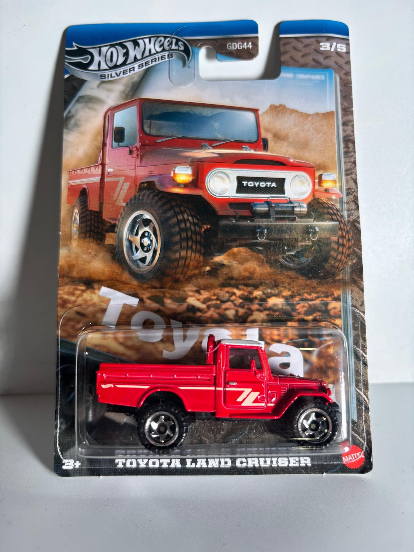 Red toy truck in packaging with Toyota branding on a gray background