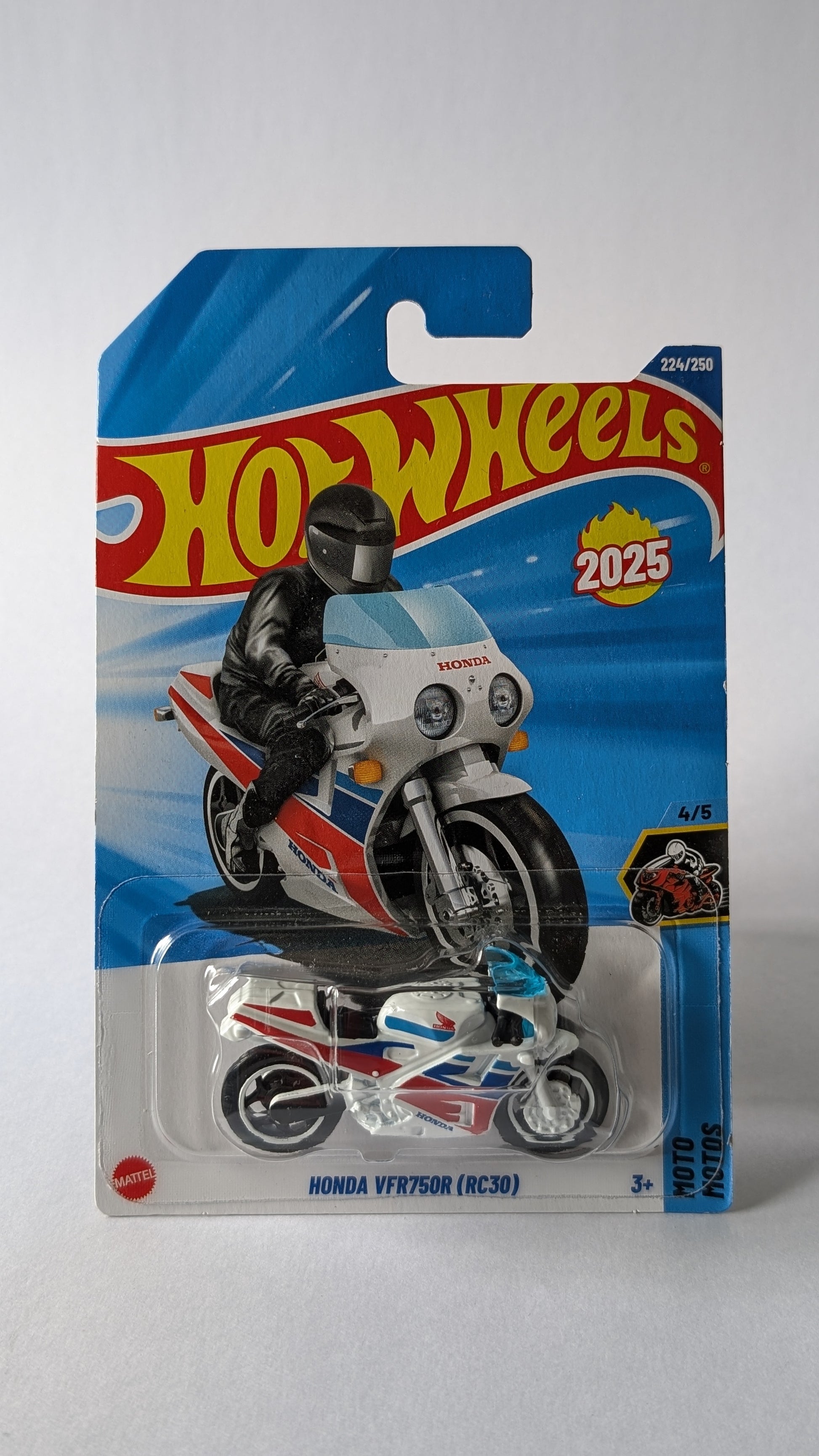 Hot Wheels motorcycle toy in packaging with '2025' branding on a gray background